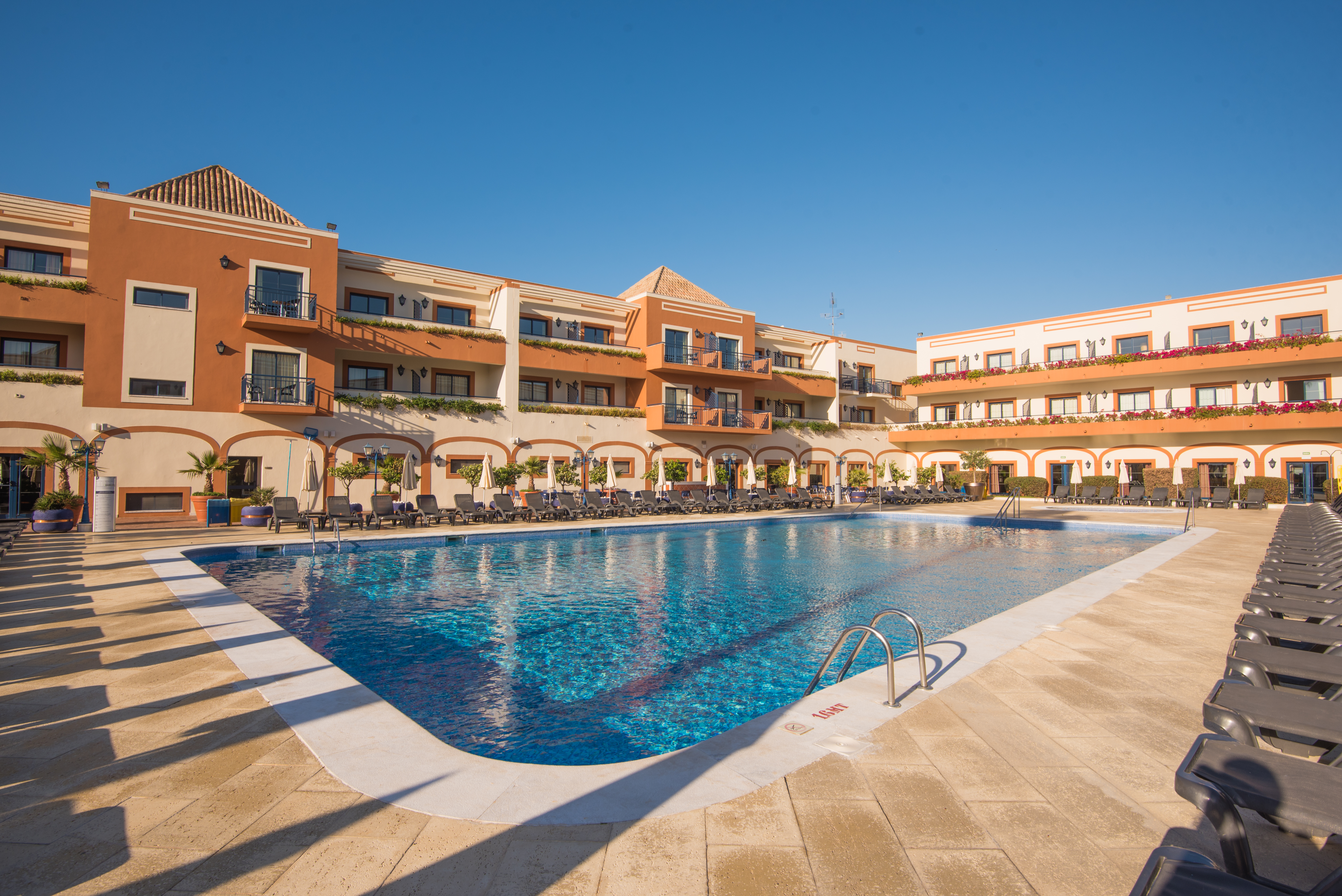 Outdoor swimming pool and sun loungers at the Vila Galé Tavira hotel in Portugal.