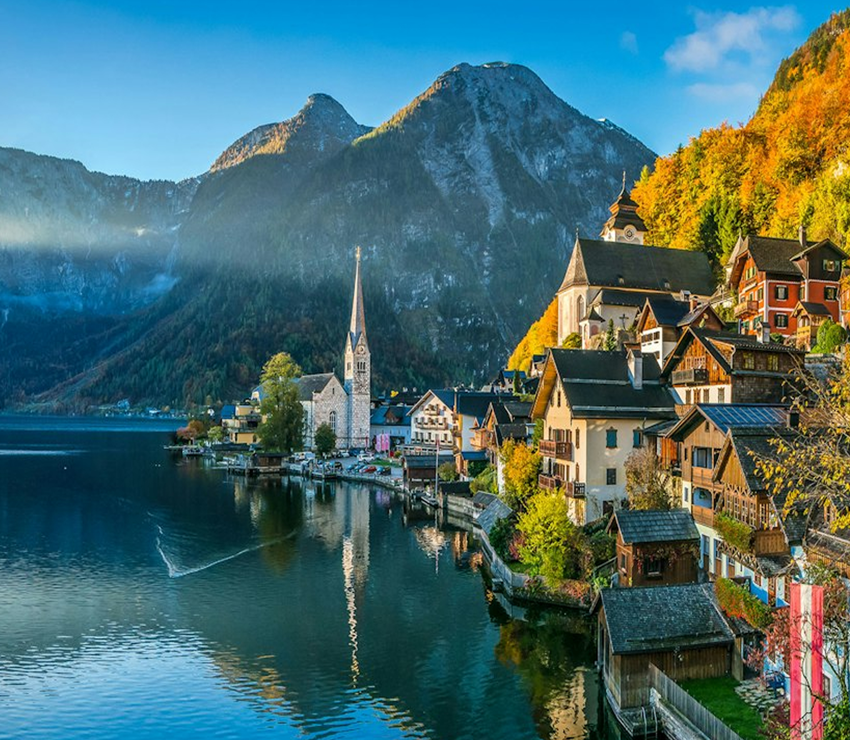 Scenic view of Hallstatt, Austria, with lakeside houses and church beneath the mountains.